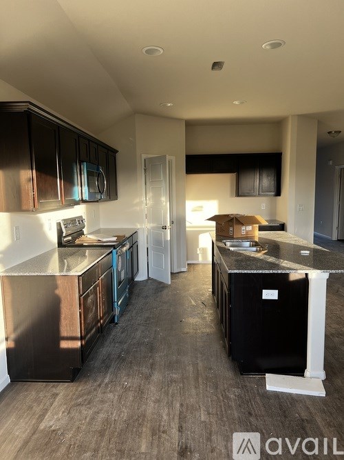 A kitchen with black cabinets and a wooden island.