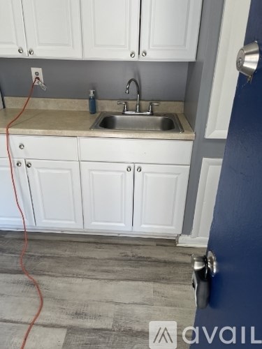 A kitchen with white cabinets and a sink.