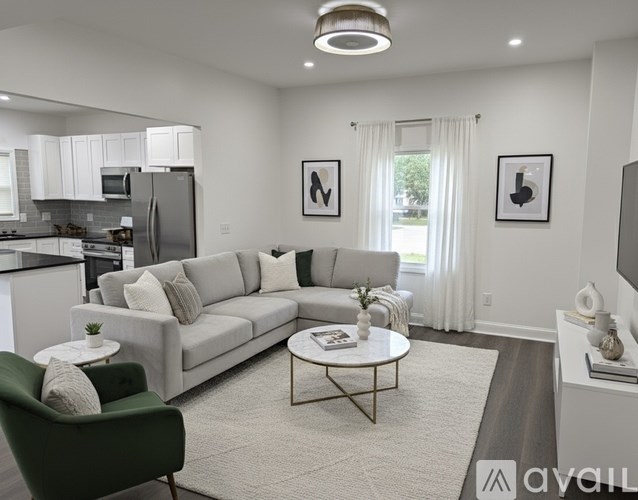 A modern living room with a grey sofa, a green armchair, and a coffee table.