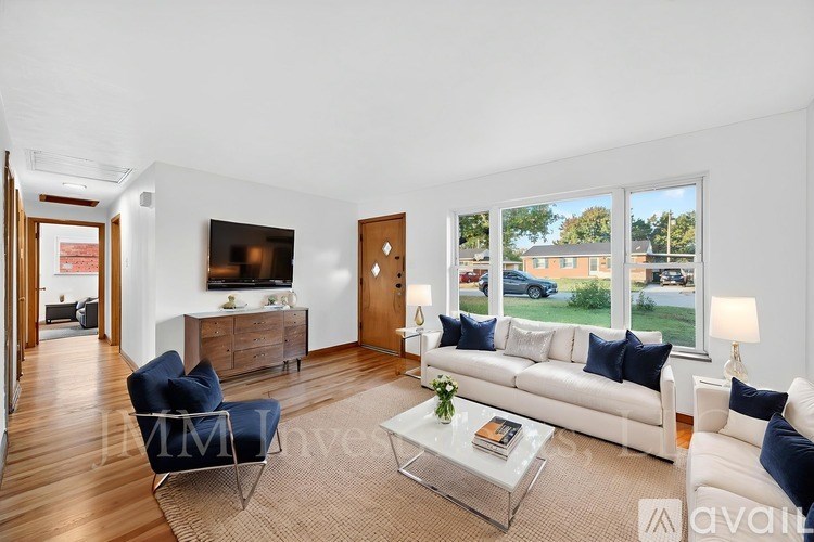 A living room with a white couch, a blue chair, and a glass coffee table.