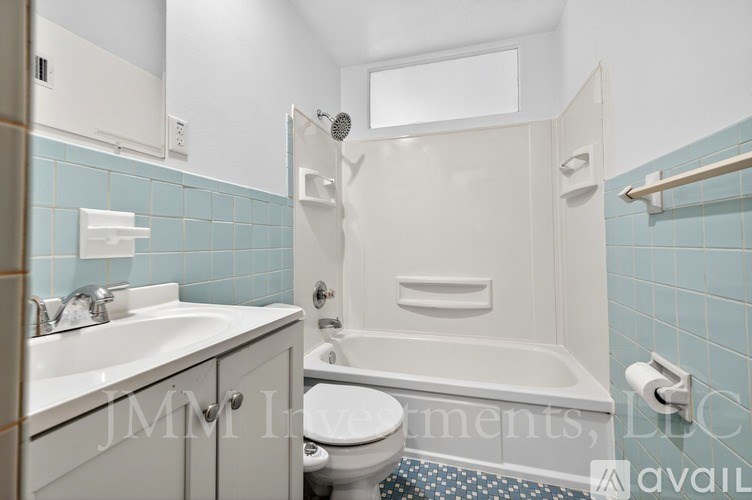 A white bathroom with a toilet, sink, and bathtub.