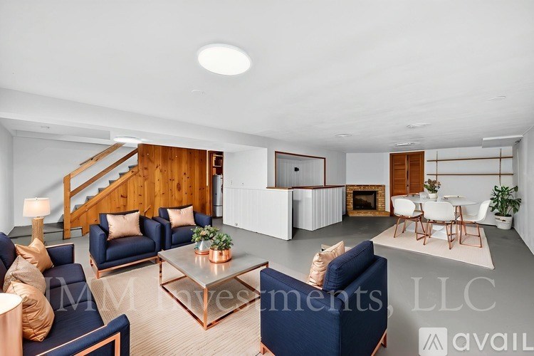 A living room with a staircase and a dining area.