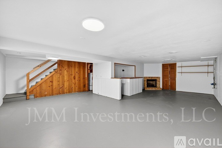 A spacious room with a staircase and a fireplace is available for rent.