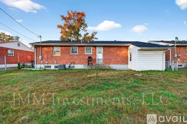 A red brick house with a white garage door is for sale.