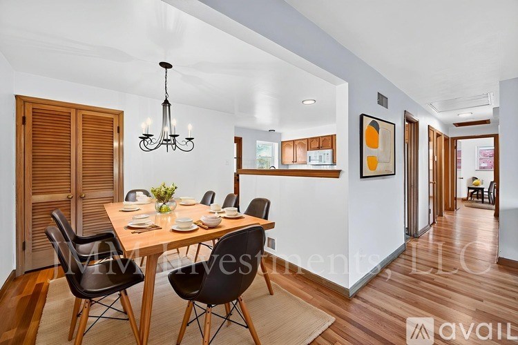 A dining room with a wooden table and chairs.