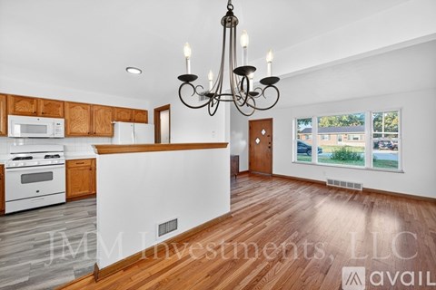 A kitchen with wooden cabinets and a white island.