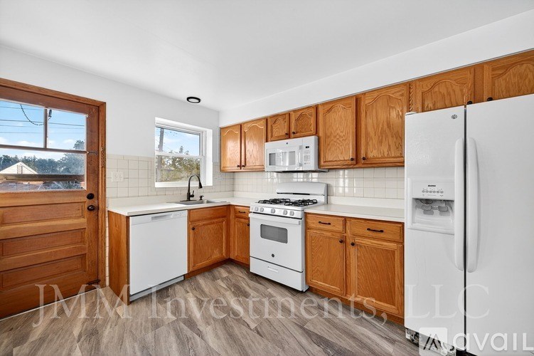 A kitchen with white appliances and wooden cabinets.