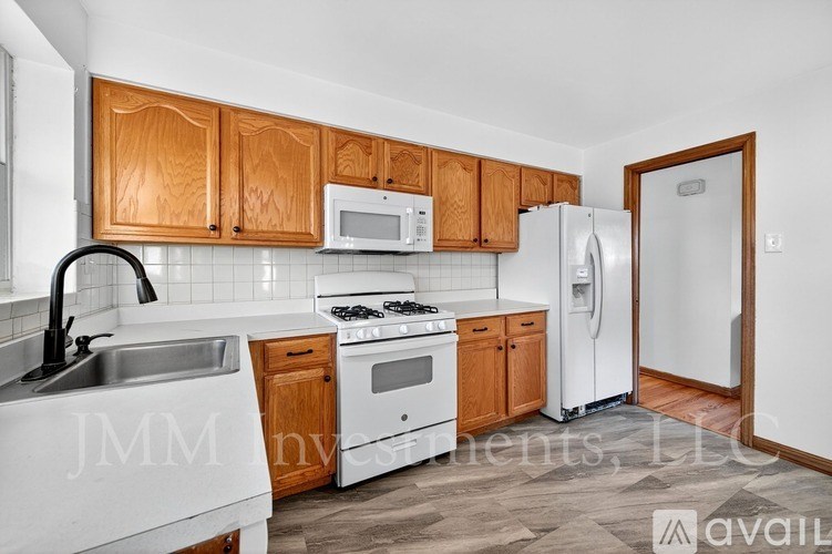 A kitchen with wooden cabinets and white appliances.