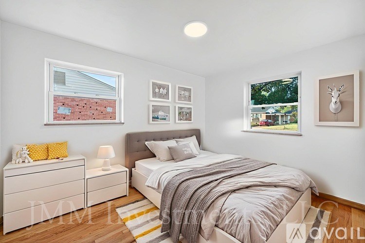 A bedroom with a bed, nightstands, and pictures on the wall.