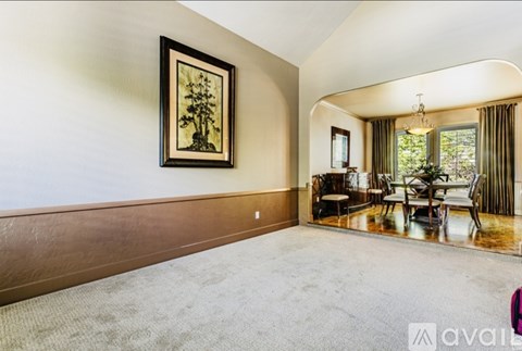 A living room with a painting of a tree on the wall.