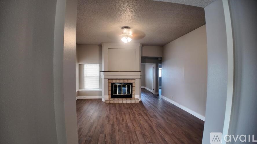 A room with a fireplace and wood flooring.