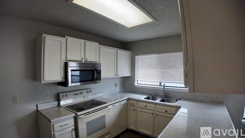A kitchen with white appliances and cabinets.