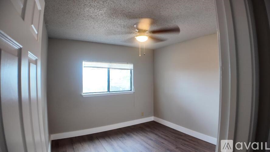 A room with a window and a ceiling fan.