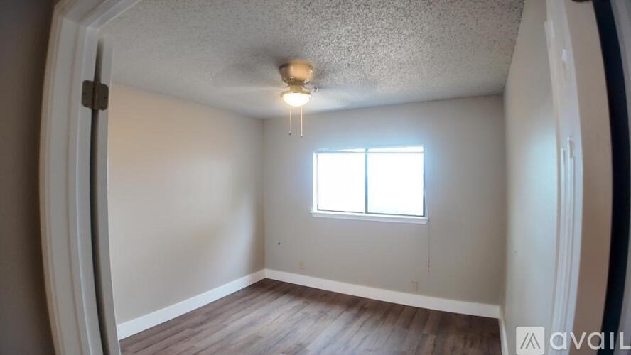 A room with a window and a light on the ceiling.