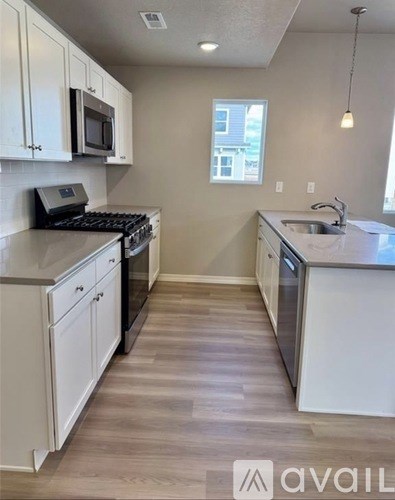 A kitchen with white cabinets and a black stove top oven.