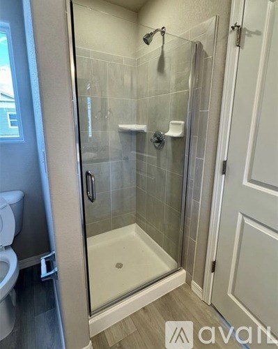 A bathroom with a glass shower door and a white toilet.