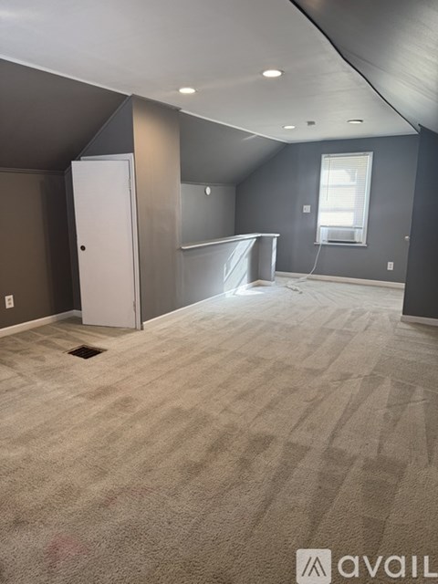 A room with a carpeted floor and a white door.
