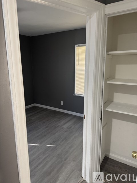 A room with a white door and shelves.