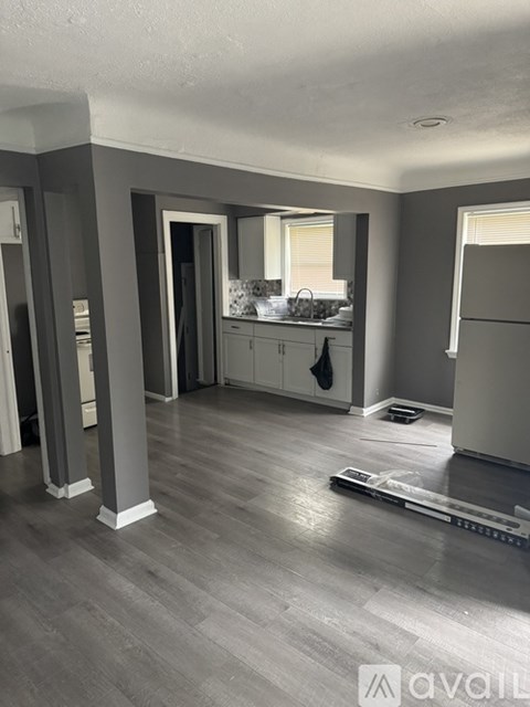 A kitchen with a sink, a window, and a refrigerator.