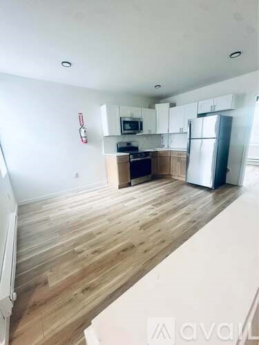 A kitchen with wooden floors and white walls.