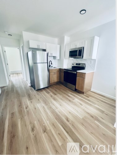 A kitchen with wooden floors and stainless steel appliances.