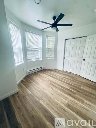 A room with wooden flooring and a ceiling fan.