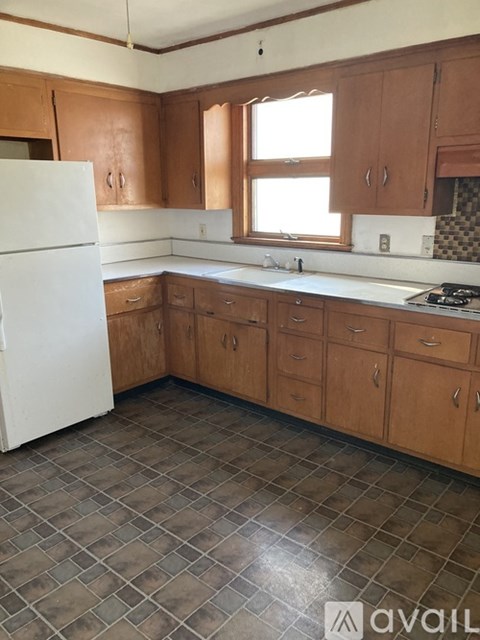A kitchen with brown cabinets and a white fridge.