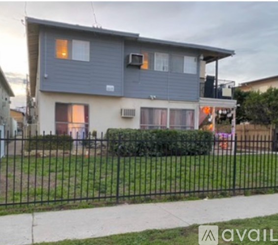 A grey house with a black fence in front.