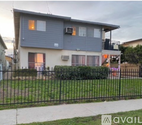 A grey house with a black fence in front.