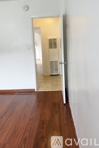 A hallway with a wooden floor and a white door.