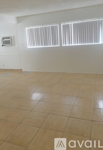 A room with tiled flooring and a window with blinds.