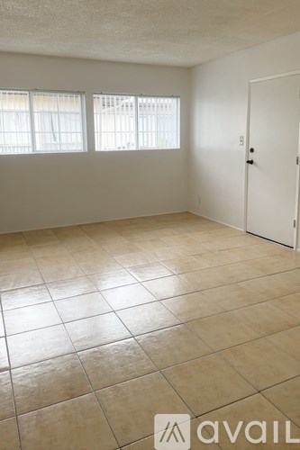 A room with tiled flooring and a door on the right side.