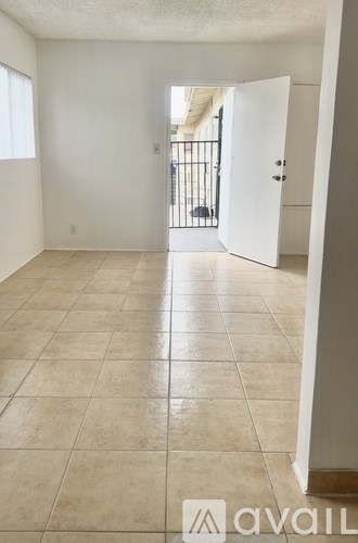 A room with tiled flooring and a doorway leading to another room.