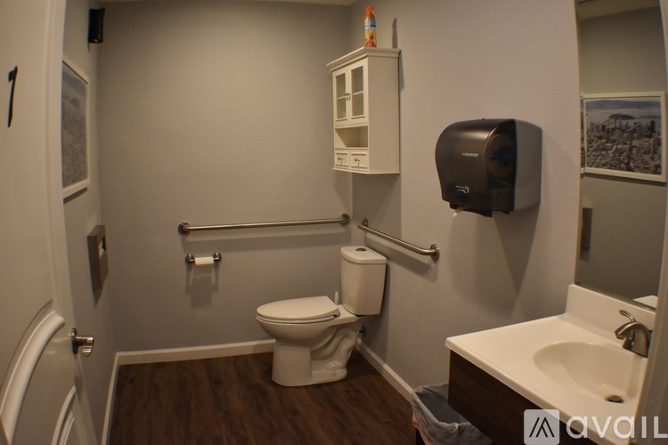 A bathroom with a toilet, sink, and towel rack.