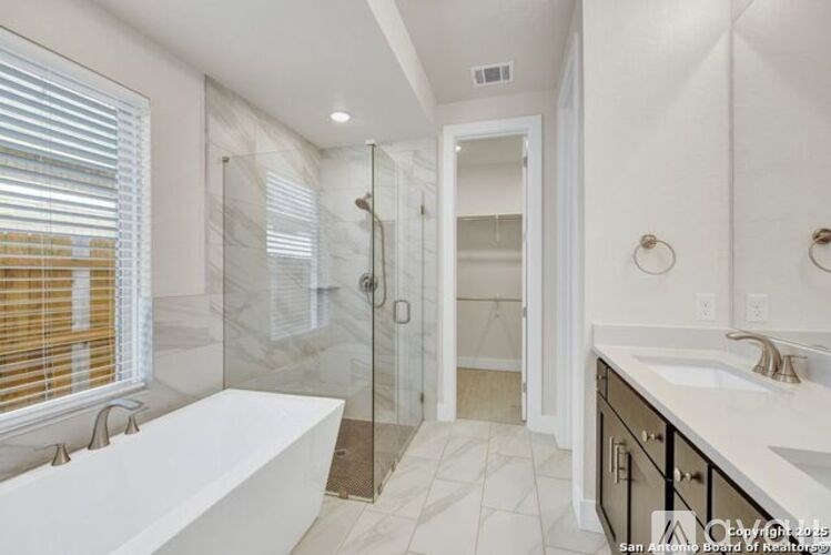 A bathroom with a white tub and a walk-in shower.