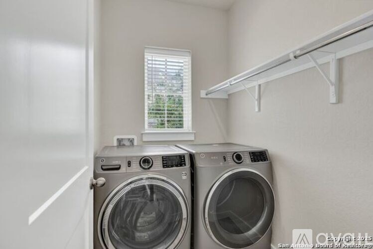 Two front load washing machines in a small laundry room.