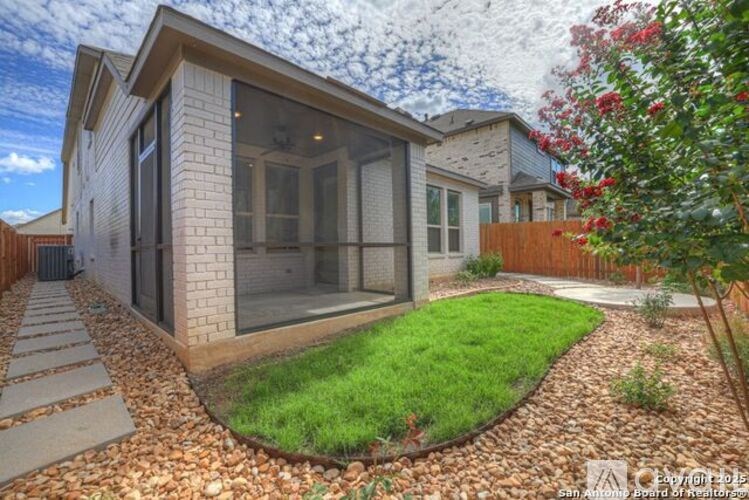 A modern house with a glass door and a small garden in front.