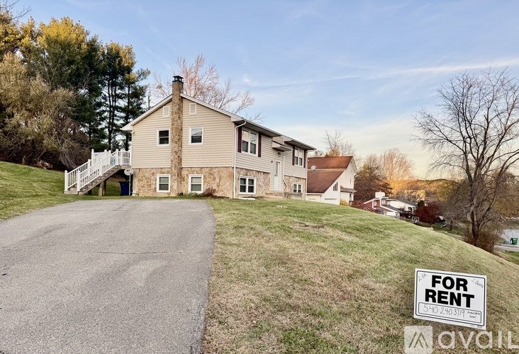 A house with a "For Rent" sign in front of it.