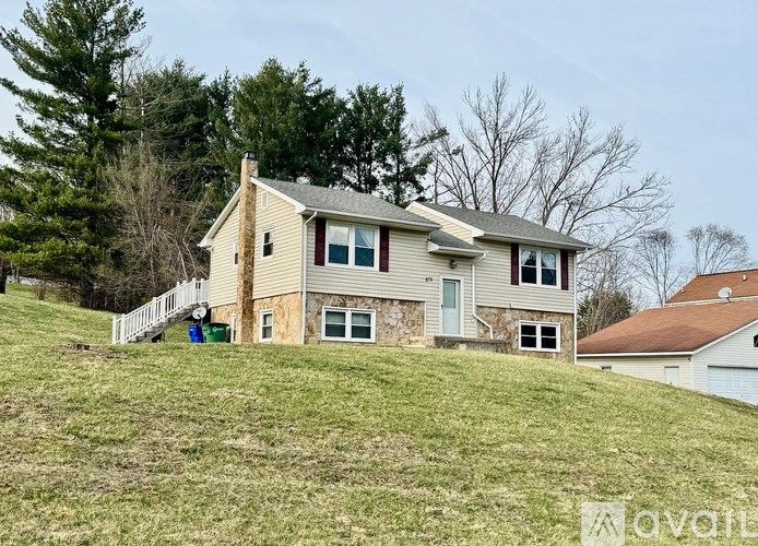 A house with a green trash can in front of it.