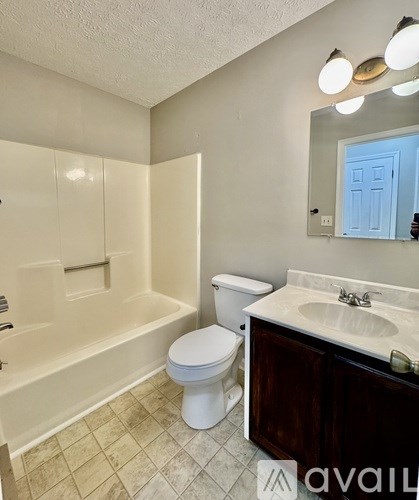 A bathroom with a toilet, sink, and bathtub.