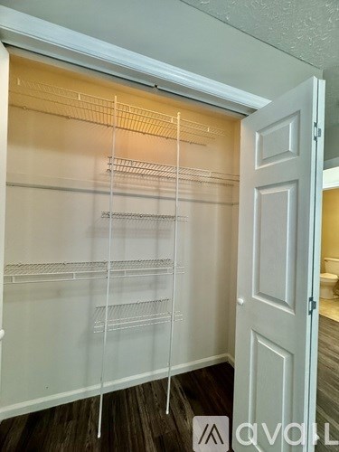 A white closet with shelves and a door.
