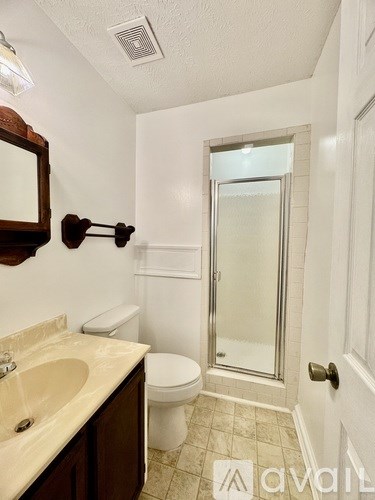 A bathroom with a toilet, sink, and shower.