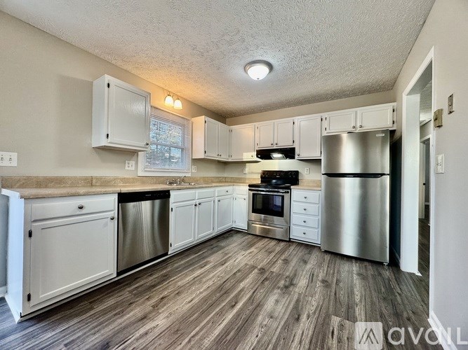A kitchen with white cabinets and stainless steel appliances.