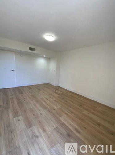 A room with wooden flooring and a white door.