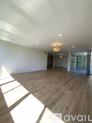 A room with wooden flooring and a glass door.