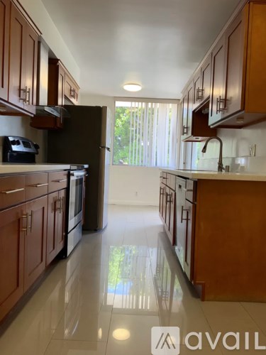 A kitchen with wooden cabinets and a black refrigerator.