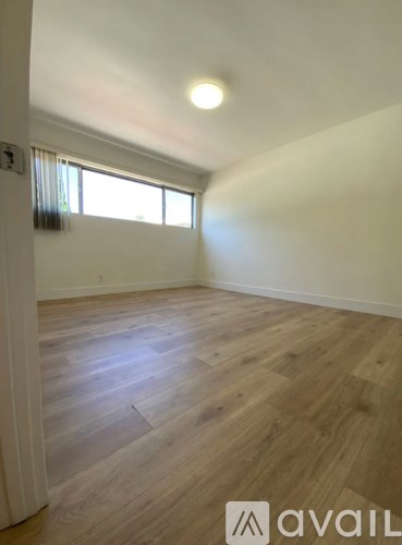 A room with wooden flooring and a window.