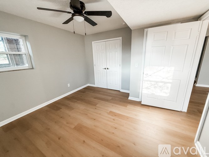 A room with wooden flooring and a ceiling fan.