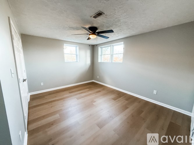 A shower area with a glass door and tiled walls.