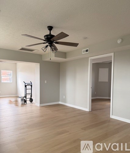 A room with a fan and a trolley in it.
